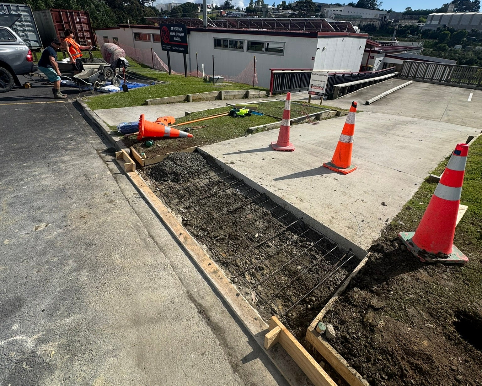 Construction site with workers and traffic cones on a clear day